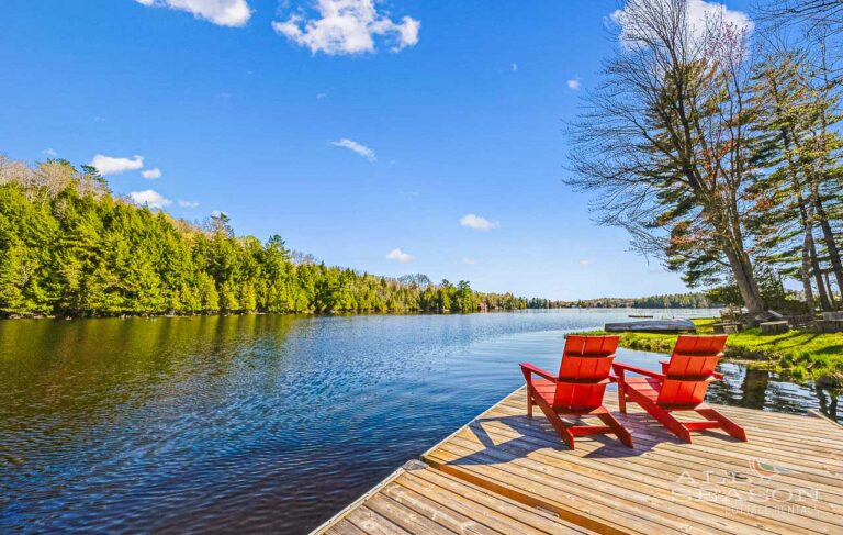 Places to visit in Ontario in summer: Adirondack chairs on lake dock in cottage country