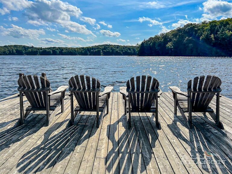 Adirondack chairs on a dock at cottage rental in Minden Ontario